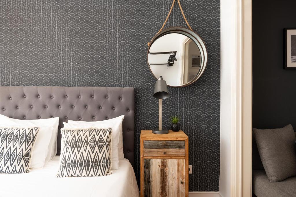 a bedroom with a bed with a mirror on the wall at DuMont Lisbon Guesthouse in Lisbon