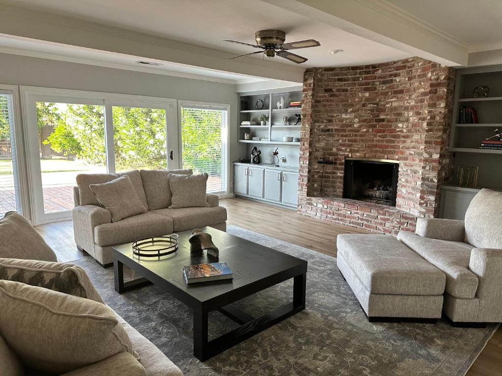 a living room with two couches and a brick fireplace at Secluded Home w/pool 5 minutes from American River in Carmichael