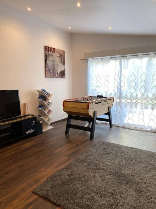 un salon avec une table de billard et une télévision dans l'établissement Logement moderne, dans mon jardin, près de Paris et stade de France avec place de stationnement, à Sannois