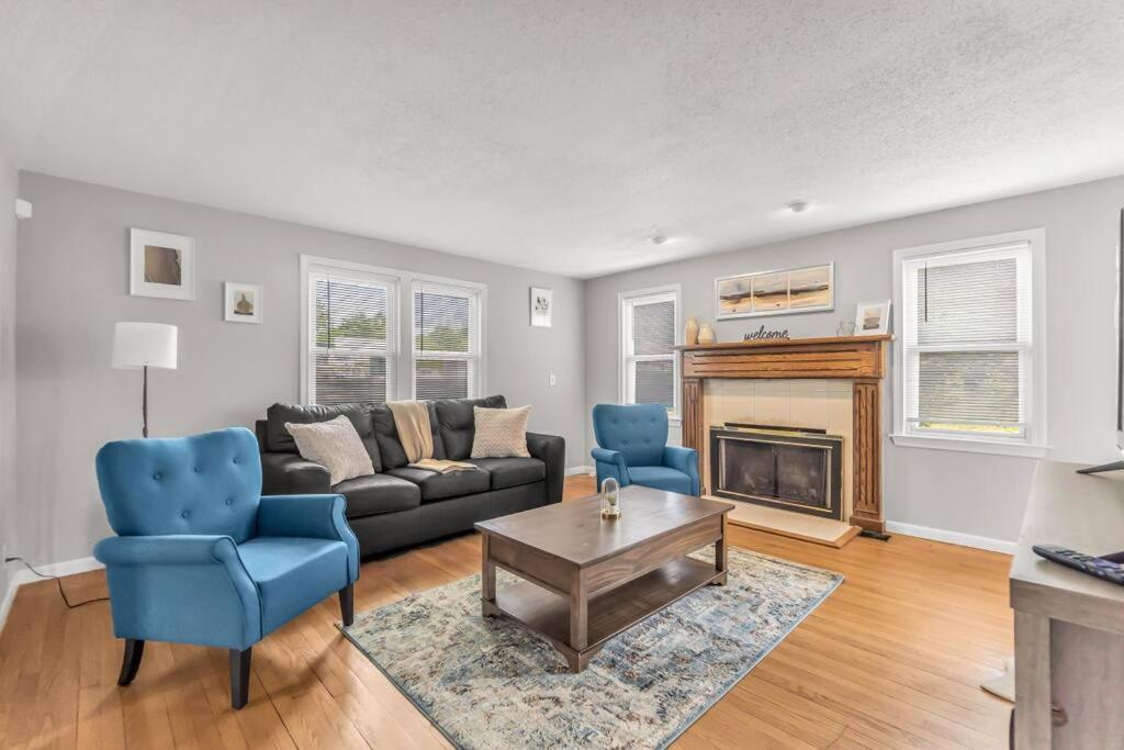 een woonkamer met een bank en stoelen en een open haard bij Comfy home with newly renovated interior in North Haven