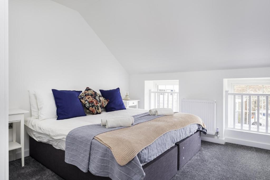 a white bedroom with a large bed with blue pillows at Modern 2bed Apartment in Worksop in Worksop