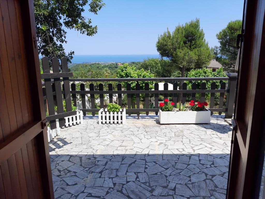 a porch with a fence and two potted plants at Patrizia's Maison in Ripatransone
