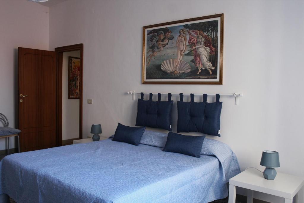 a bedroom with a blue bed and a painting on the wall at A casa di Martina, San Vito Chietino, Vico I della Chiesa in San Vito Chietino