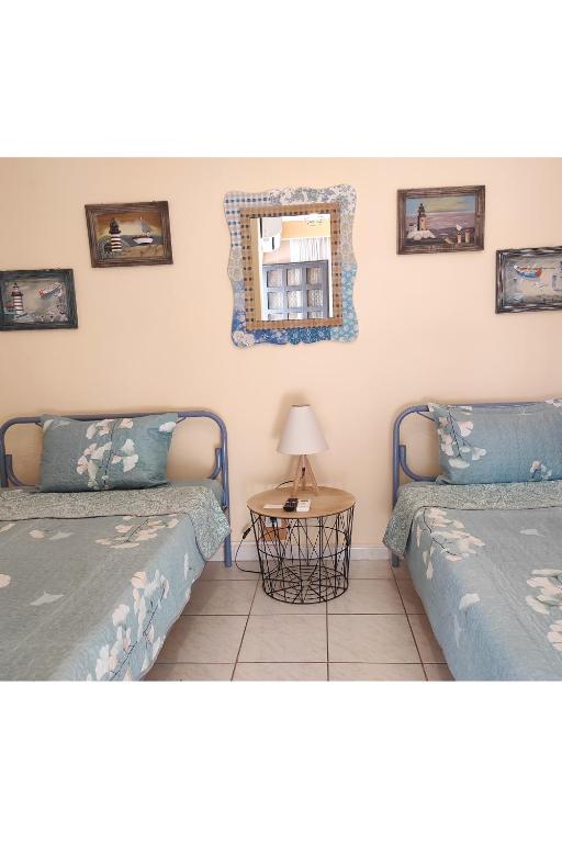 a room with two beds and a table with a mirror at Casa Stella in Agia Triada