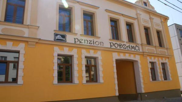 ein gelbes und weißes Gebäude mit einem Schild darauf in der Unterkunft Penzion Podzámčí in Jaroslavice