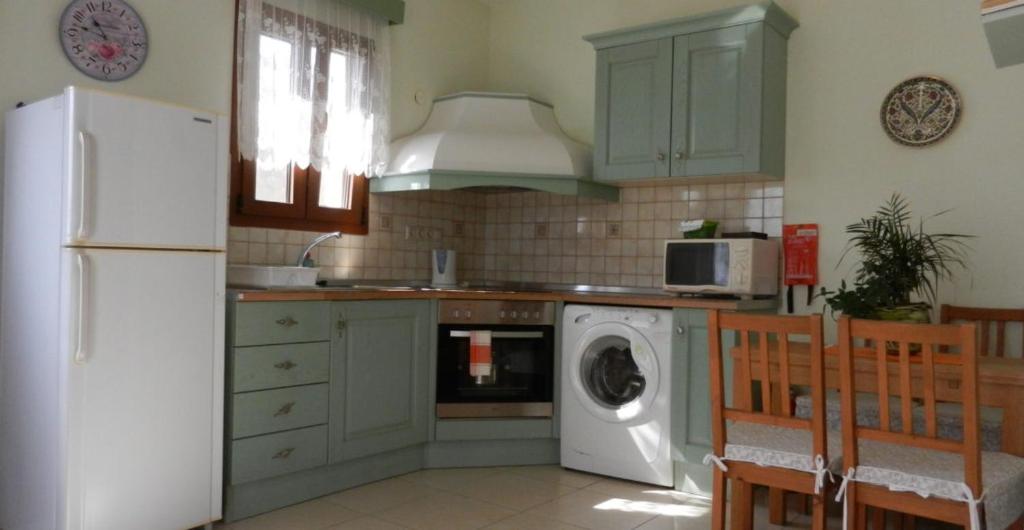 a kitchen with a white refrigerator and a washing machine at ANEMOESSA APTS in Livadia