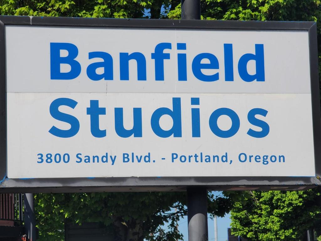 a sign for a bankaffiliated studios in front of trees at Banfield Studios in Portland