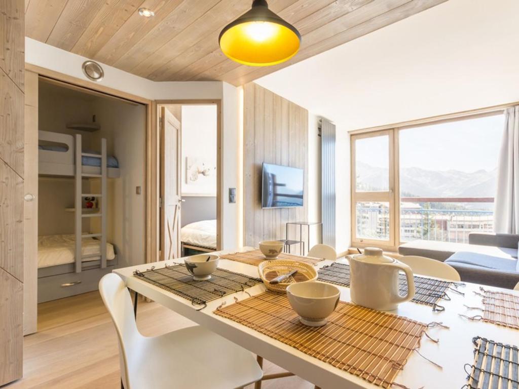 une salle à manger avec une table et des chaises et une chambre dans l'établissement Appartement rénové 6 pers · Balcon Sud-Ouest · Centre station Arc 1800 · Wifi gratuit - FR-1-346-343, à Arc 1800