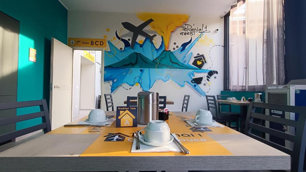 una sala da pranzo con tavolo e dipinto sul muro di Terminal 1 Guest House a Napoli