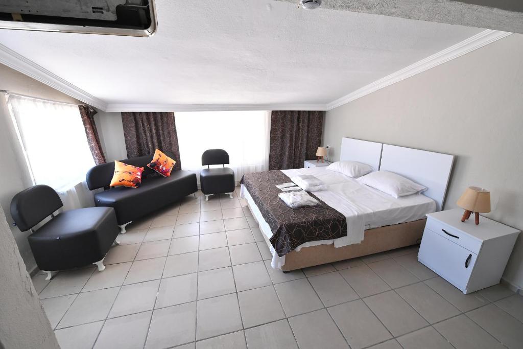 1 dormitorio con cama y sofá en Nilhan Otel en Ören