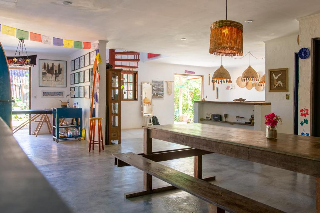 a dining room with a wooden table in a room at Sambaqui Hostel in Ilhabela
