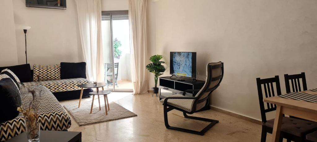 ein Wohnzimmer mit einem Sofa und einem TV in der Unterkunft Joli appartement Mohammédia in Mohammedia