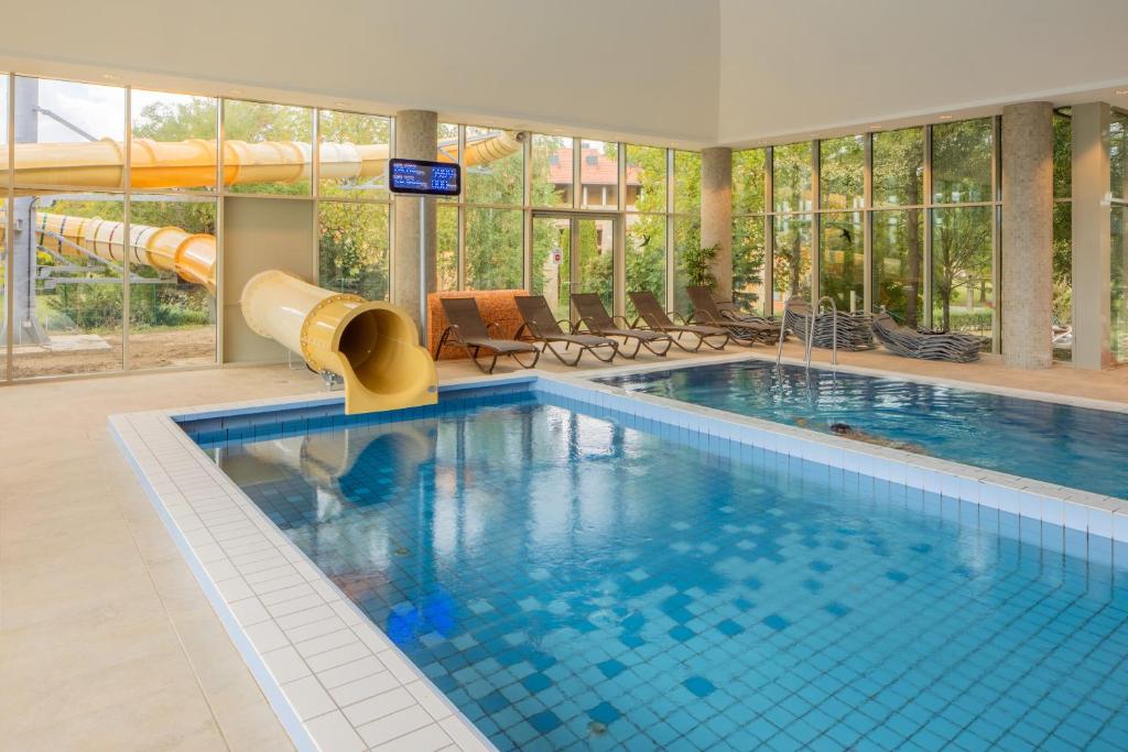 uma piscina com um escorrega no meio em Greenfield Hotel Golf & Spa Superior em Bük