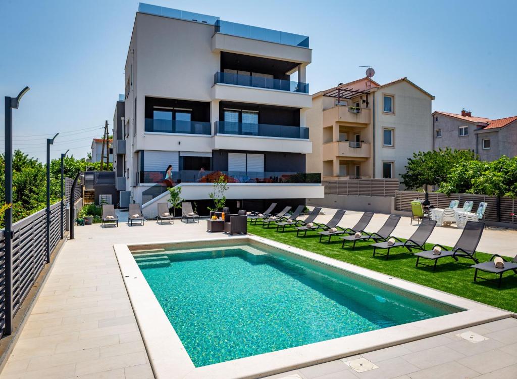 a swimming pool in front of a house at KM Exclusive Apartments in Zadar