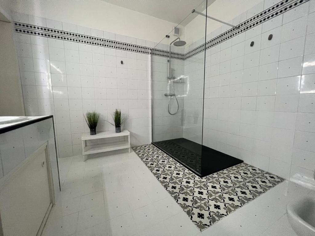 a white bathroom with a glass shower with plants at B&B Giulianova in Giulianova