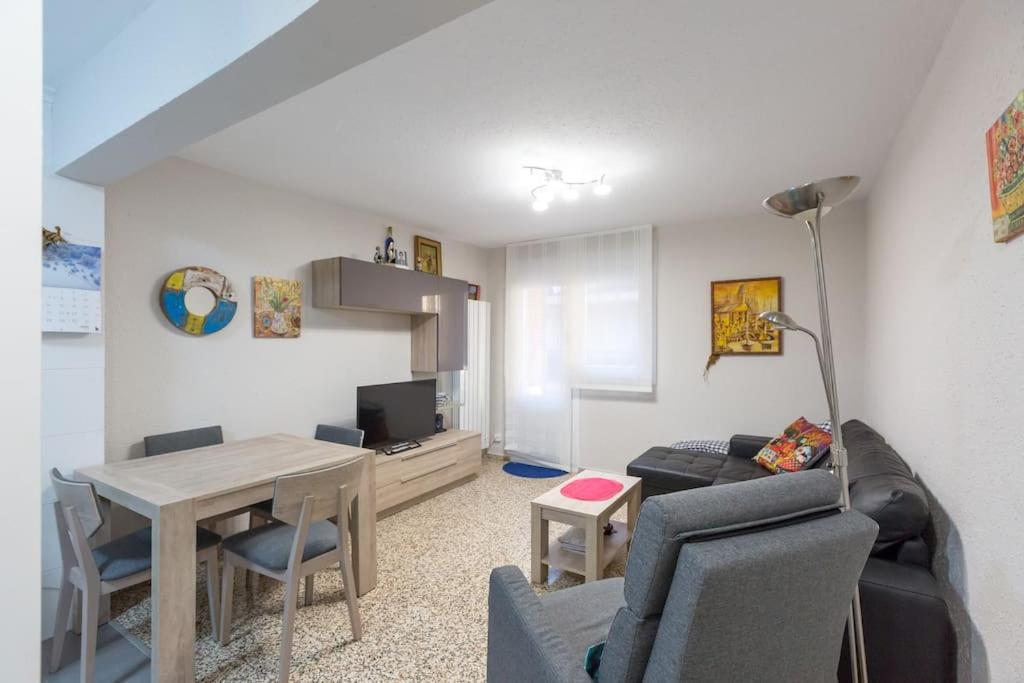 uma sala de estar com um sofá e uma mesa com cadeiras em Apartamento en Santoña em Santoña