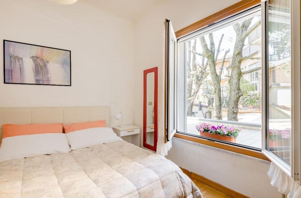 um quarto com uma cama e uma grande janela em Residence Rialto em Milano Marittima