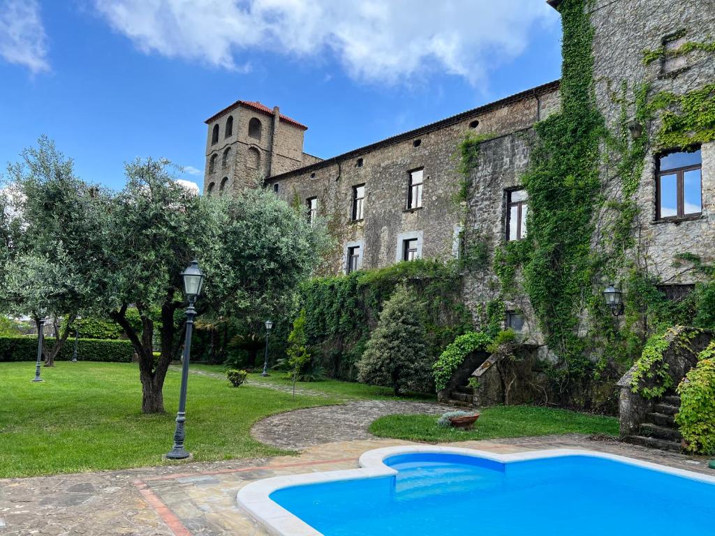 een oud gebouw met een zwembad ervoor bij Relais Castello Vassallo in Stella Cilento