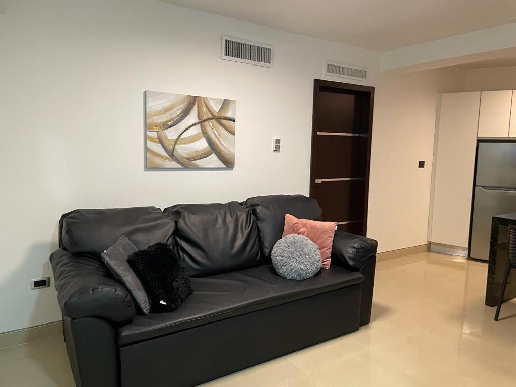 un sofá de cuero negro en la sala de estar en Elegante apartamento en Playa el Angel en Porlamar