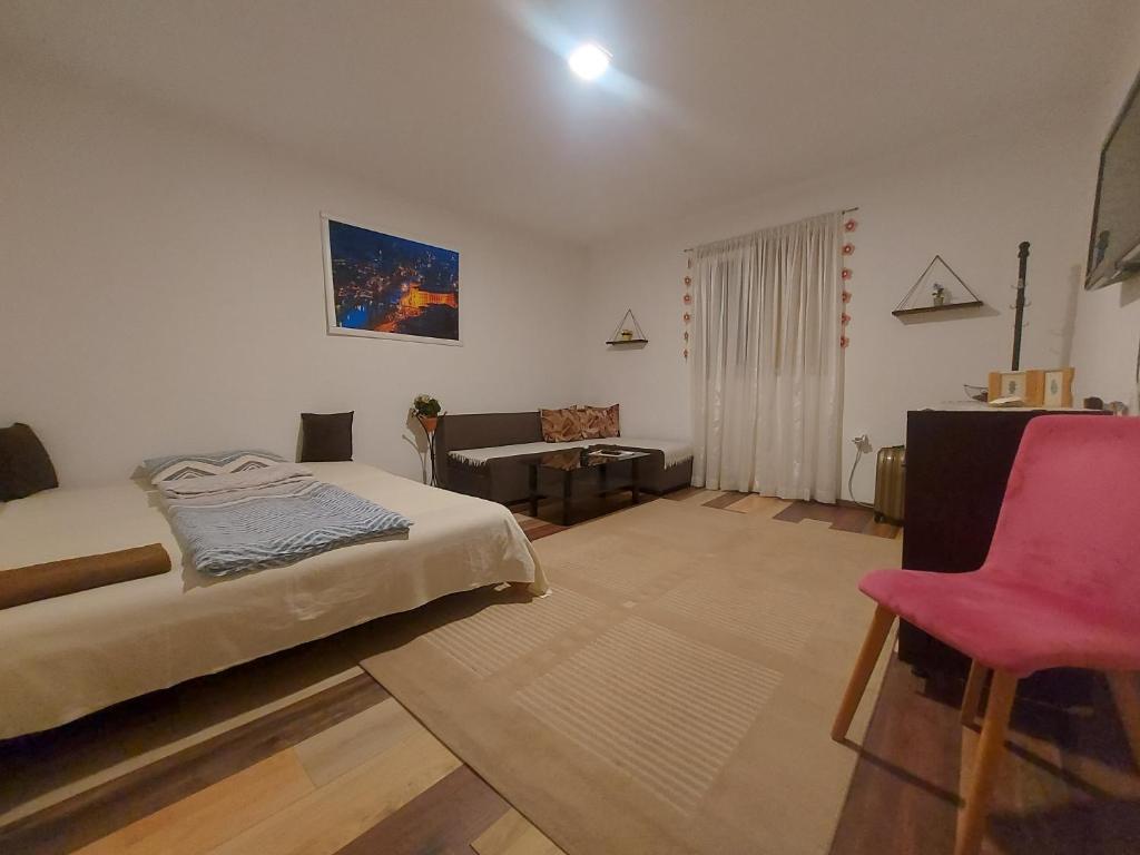 ein Schlafzimmer mit einem Bett und einem roten Stuhl in der Unterkunft Pandora's Place in Sarajevo