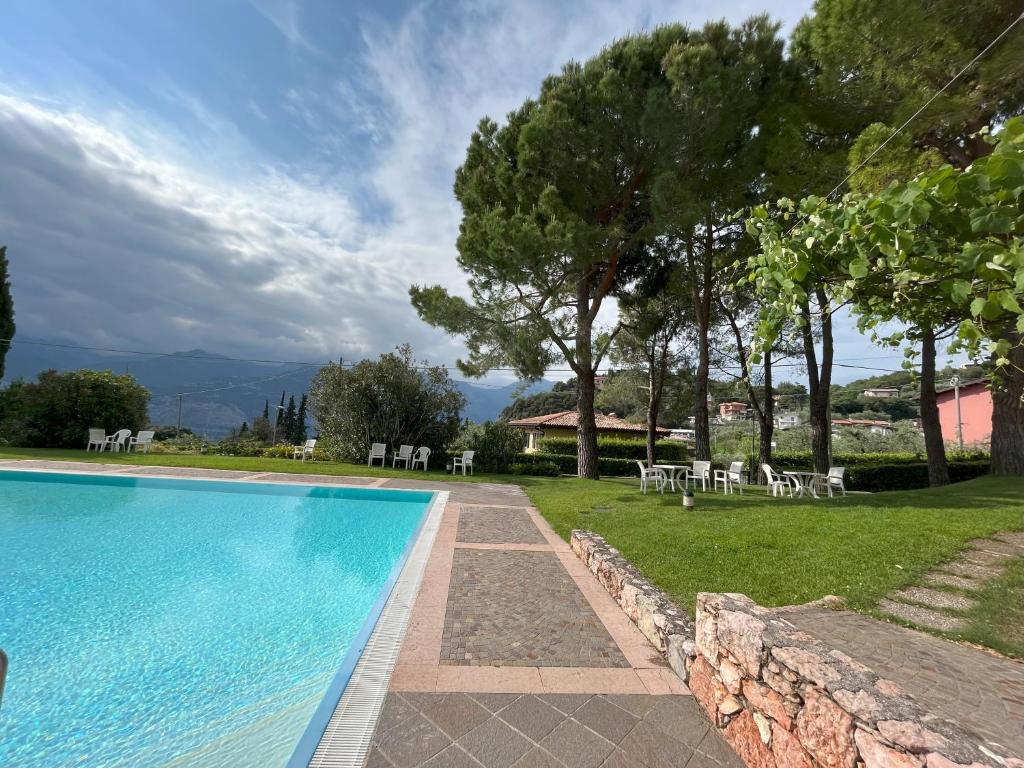 a view of a swimming pool with chairs and trees at Apartment Claudia Malcesine in Malcesine
