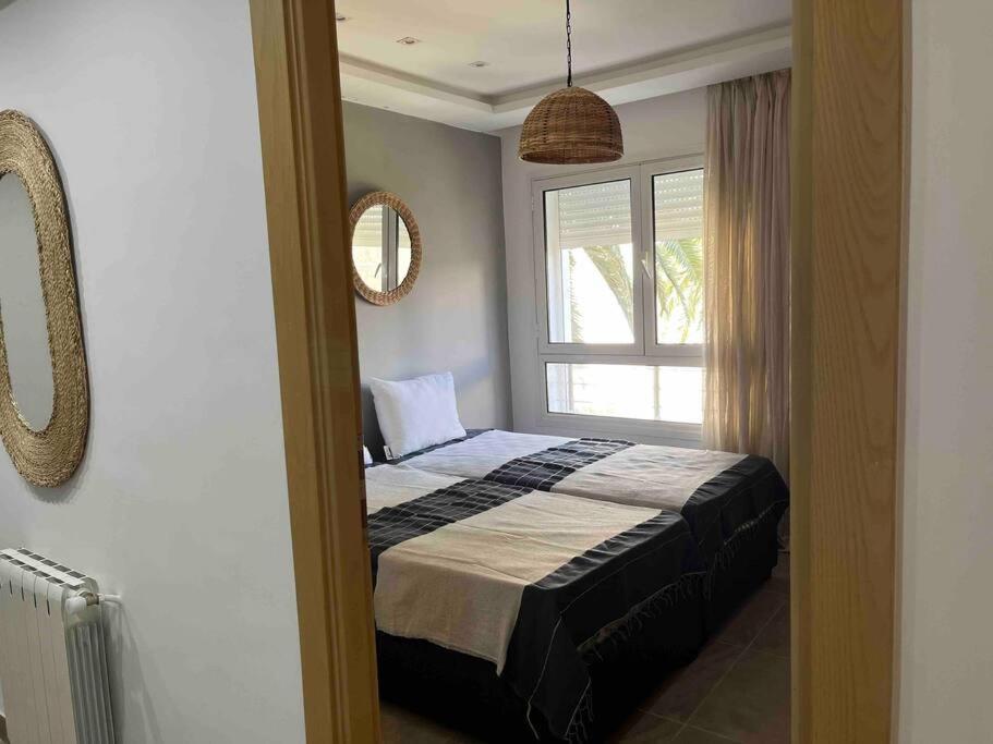 een slaapkamer met een bed en een raam bij Duplex à Hammamet centre in Hammamet Sud