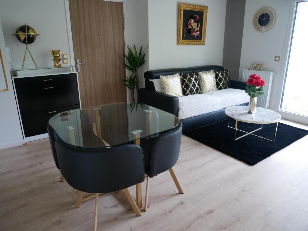uma sala de estar com uma mesa de vidro e um sofá em Appartement sublime em Romainville