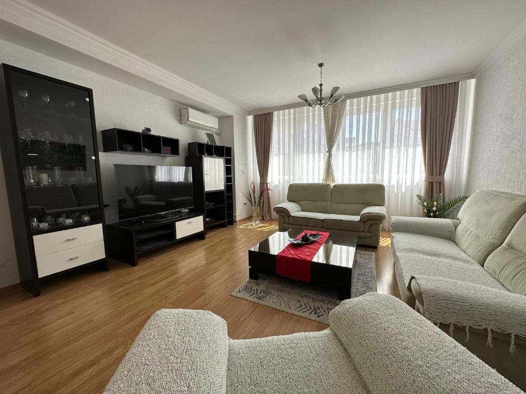 ein Wohnzimmer mit 2 Sofas und einem TV in der Unterkunft Spacious 3-bedroom Condo Next to City Center in Pristina