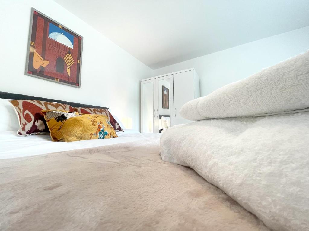 um quarto com uma cama grande e lençóis brancos em Tree View Apartment em Chesterton