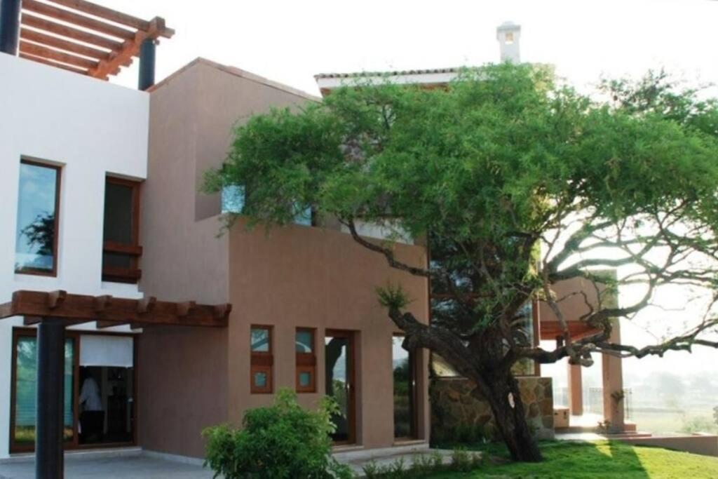 uma casa com uma árvore em frente em Luxury in San Miguel at its best. em San Miguel de Allende