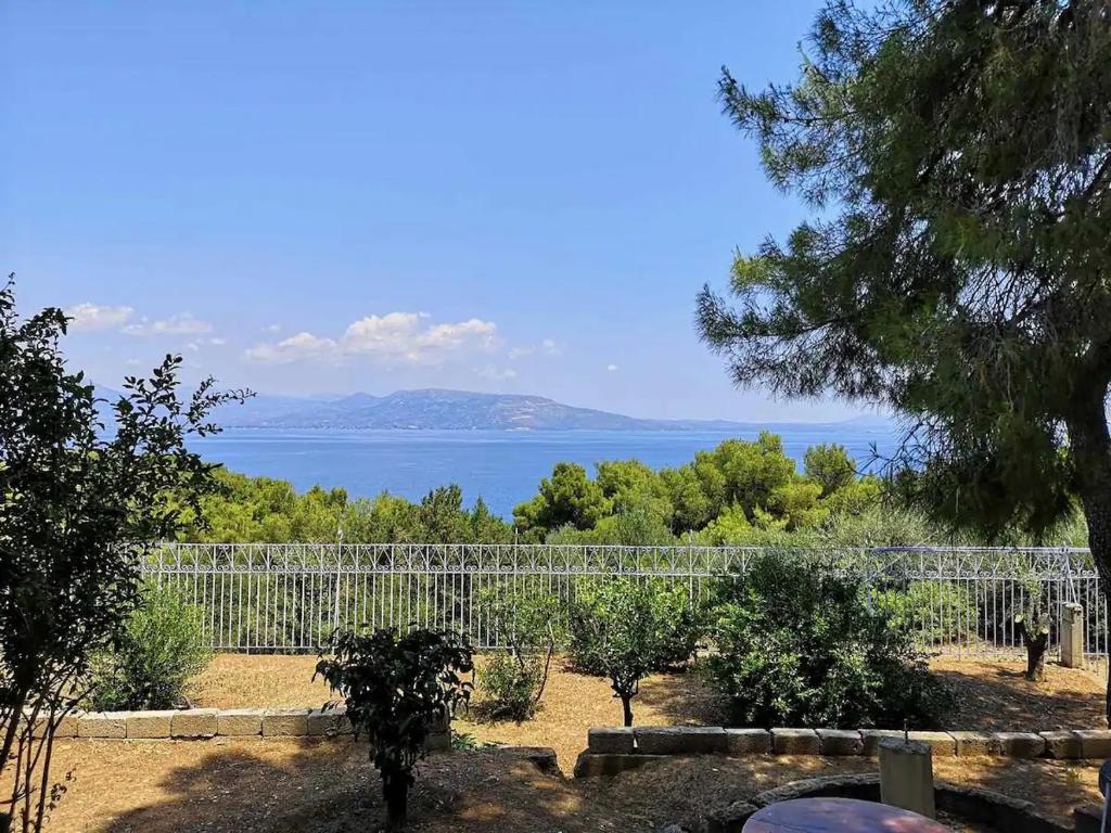 a view of the ocean from a garden at Panorama View Apartment 3 in Áyioi Apóstoloi