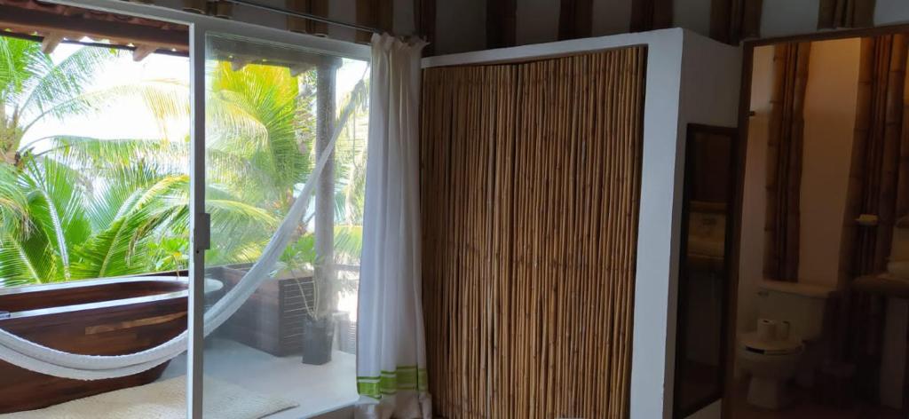 a room with a window with a hammock and a tub at Hotel Bendita Luna Salchi in Cuatunalco