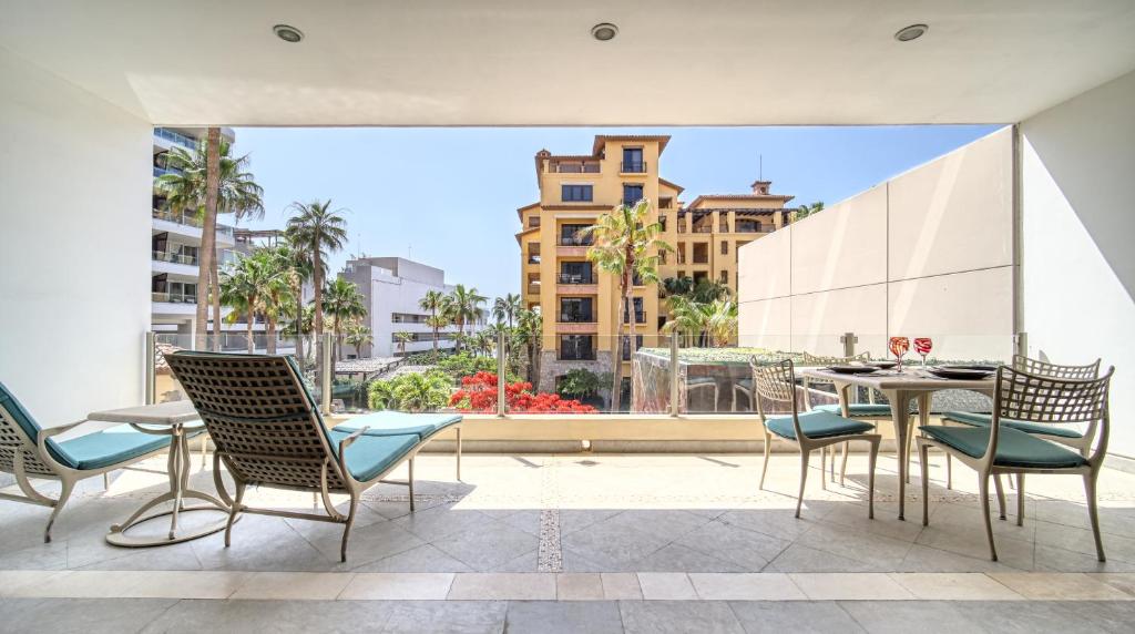 balcón con mesa, sillas y vistas a la ciudad en One Medano 8B, en Cabo San Lucas
