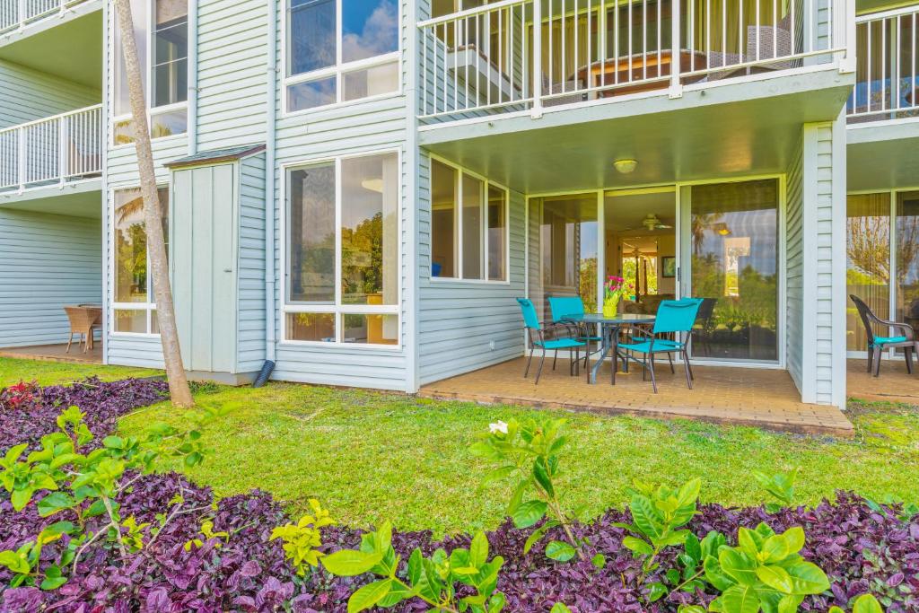 a house with a patio with a table and chairs at Beautiful Princeville Garden Condo with lots of Amenities C2108 in Princeville
