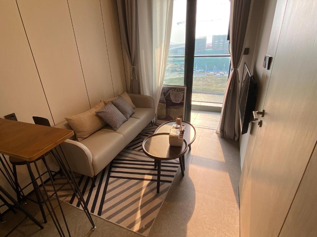 ein kleines Wohnzimmer mit einem Sofa und einem Tisch in der Unterkunft Ruby’s in Bao'an