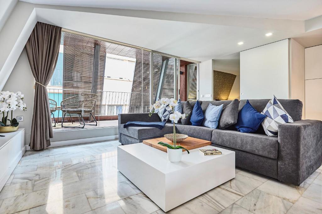 a living room with a couch and a table at Hello Alicante Apartamentos in Alicante