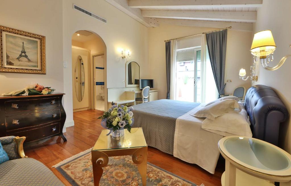 a bedroom with a bed and a living room at Hotel Globus, Sure Hotel Collection by Best Western in Milano Marittima