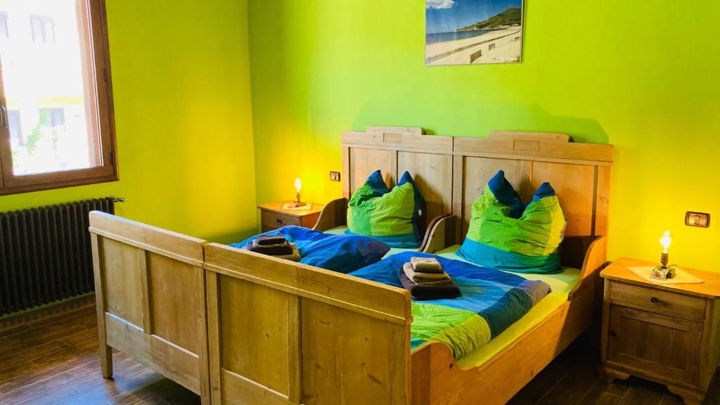um quarto com uma cama de madeira e paredes verdes em Il Rustico em Fluminimaggiore