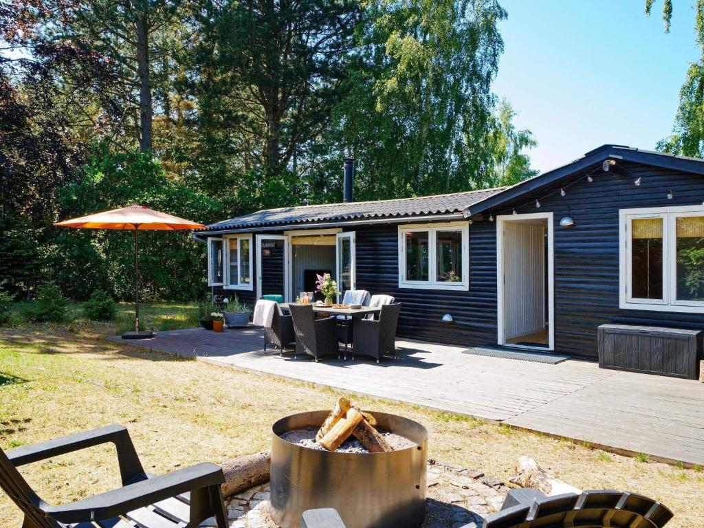 een blauw huis met een tafel, stoelen en een grill bij 6 person holiday home in Jægerspris-By Traum in Jægerspris