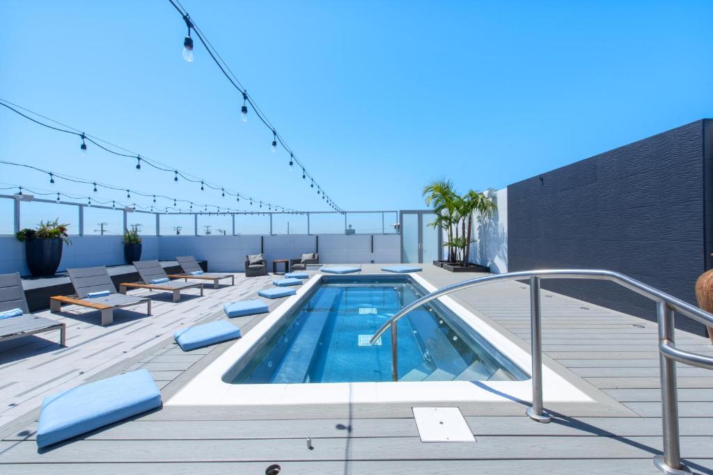 a rooftop deck with a swimming pool on a building at Shade Hotel Manhattan Beach in Manhattan Beach