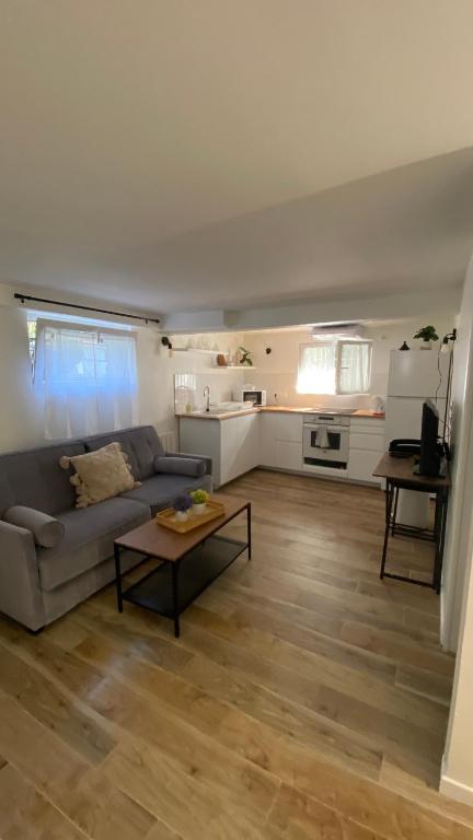 ein Wohnzimmer mit einem Sofa und einem Tisch in der Unterkunft Studio proche de Paris et des transports in Villemomble