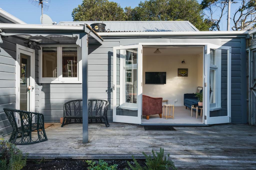 un patio con divano e sedie a pianta aperta. di Cottage on Aotea a Dunedin