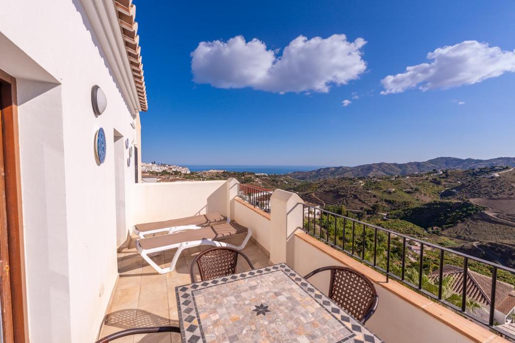 a balcony with chairs and a view of the mountains at Apartamento Chic in Frigiliana