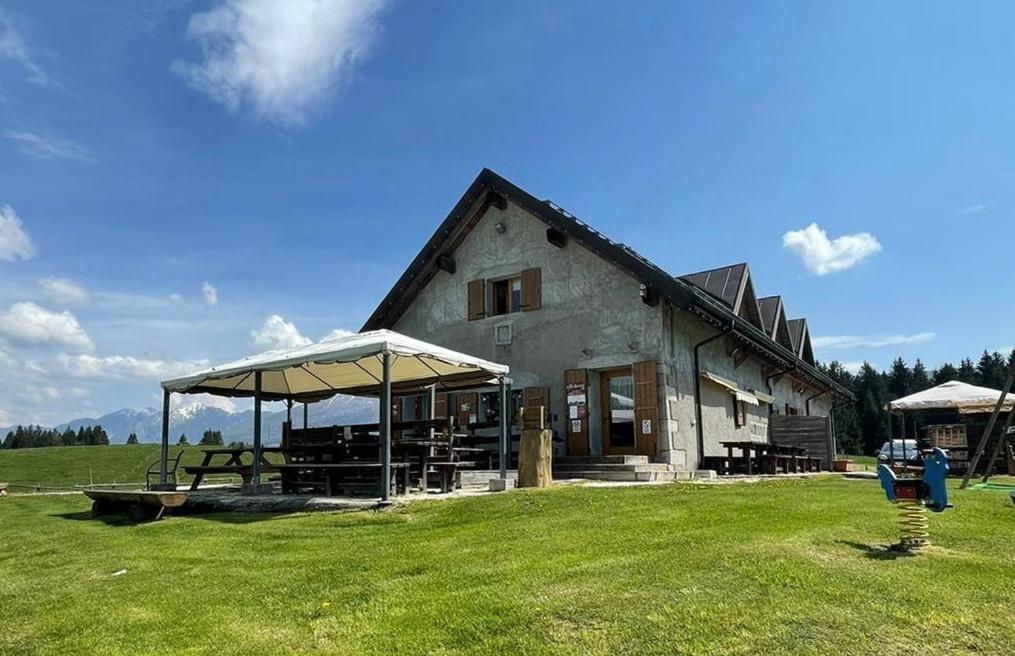 a building with a picnic table in a field at Agriturismo Filippon in Tambre dʼAlpago