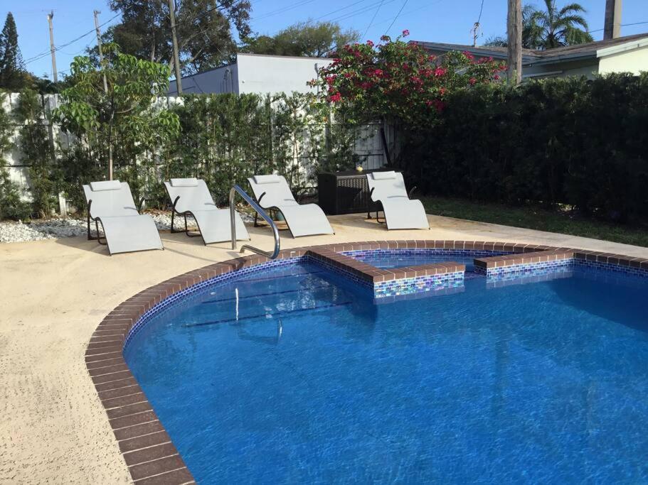 a group of chairs and a swimming pool at Home with heated pool close to beach and FLL airport in Fort Lauderdale