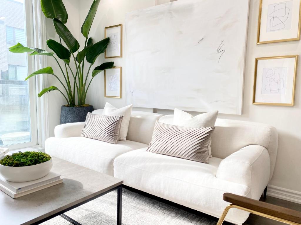 a living room with a white couch and a table at Modern and Bright Luxury Home Centrally Located in Toronto’s GTA in Toronto