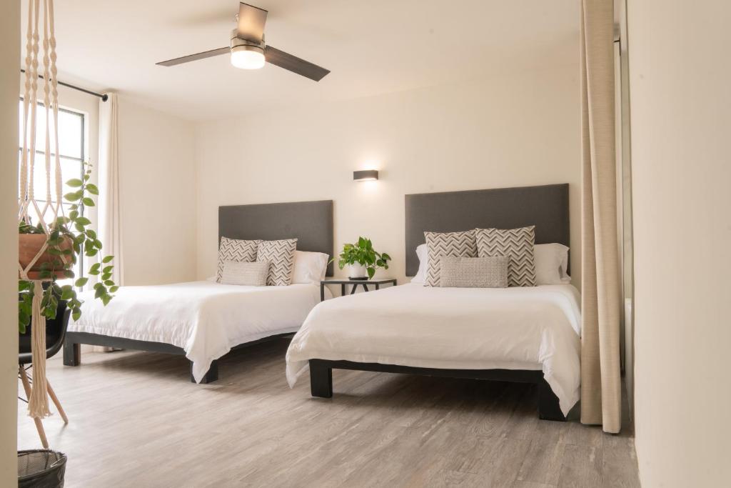 a bedroom with two beds and a ceiling fan at Hotel Casa Guadiana in San Miguel de Allende