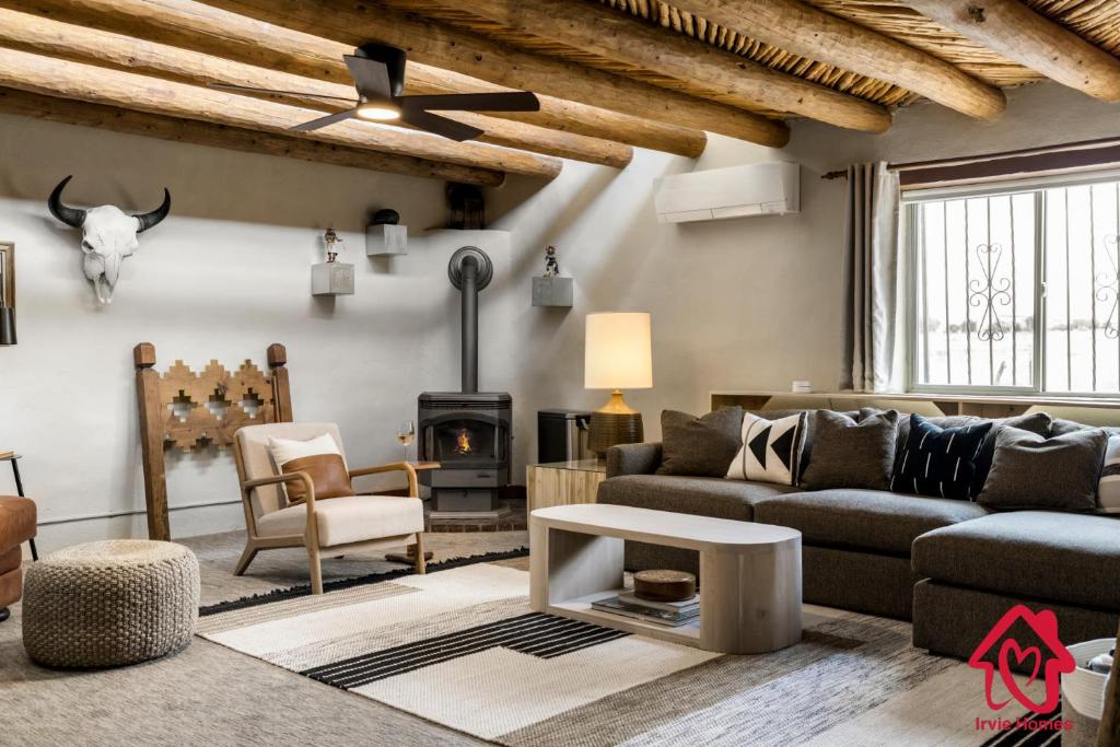 een woonkamer met een bank en een open haard bij Rancho de La Luna Casita in Santa Fe