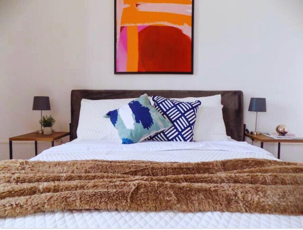ein Bett mit einer braunen Decke und Kissen darauf in der Unterkunft Urban Hotel in Guatemala