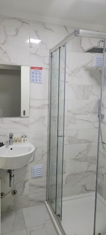 uma casa de banho com um chuveiro e um lavatório. em Bela Alexandra Guest House em Fuzeta